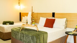 Habitación de hotel con dos camas, cabecero de madera, mesita de noche con bandeja y lámpara colgante.