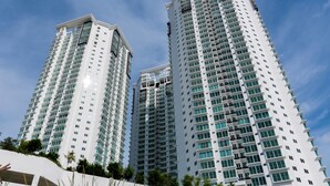 A high-rise building with multiple floors and balconies, surrounded by greenery. - Southwest Designer's Suite by D Imperio Homestay (George Town)