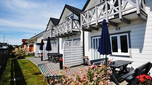 A white building with a balcony and outdoor seating area. - The newly built "White Cottage Lux", Grzybowo in Um Kolberg, 1-6 persons (Grzybowo)