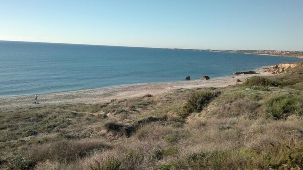 A coastal landscape with a beach, rocky outcrops, and sparse vegetation. - Modern renovated holiday home with panoramic terrace, close to sea and mountains (Seneghe)
