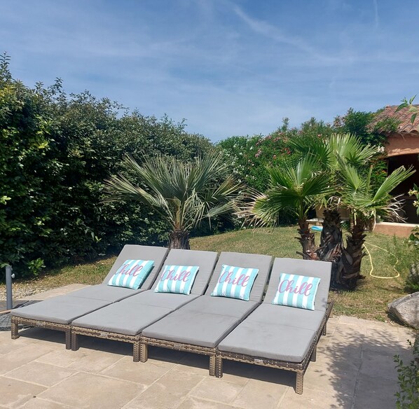 Four lounge chairs with 'Chill' pillows, surrounded by greenery and a clear sky. - pleasant house for holidays with friends or family in Provence (Entrechaux)