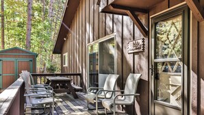 Une cabane en bois dotée d’une véranda, de meubles d’extérieur et d’une porte en verre.