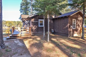 Une cabane rustique dotée d’une terrasse, d’un petit abri de jardin et d’une pancarte sur laquelle on peut lire « LUGHAVEN ».