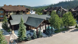 A lodge with multiple buildings, outdoor seating, and a mountain backdrop.