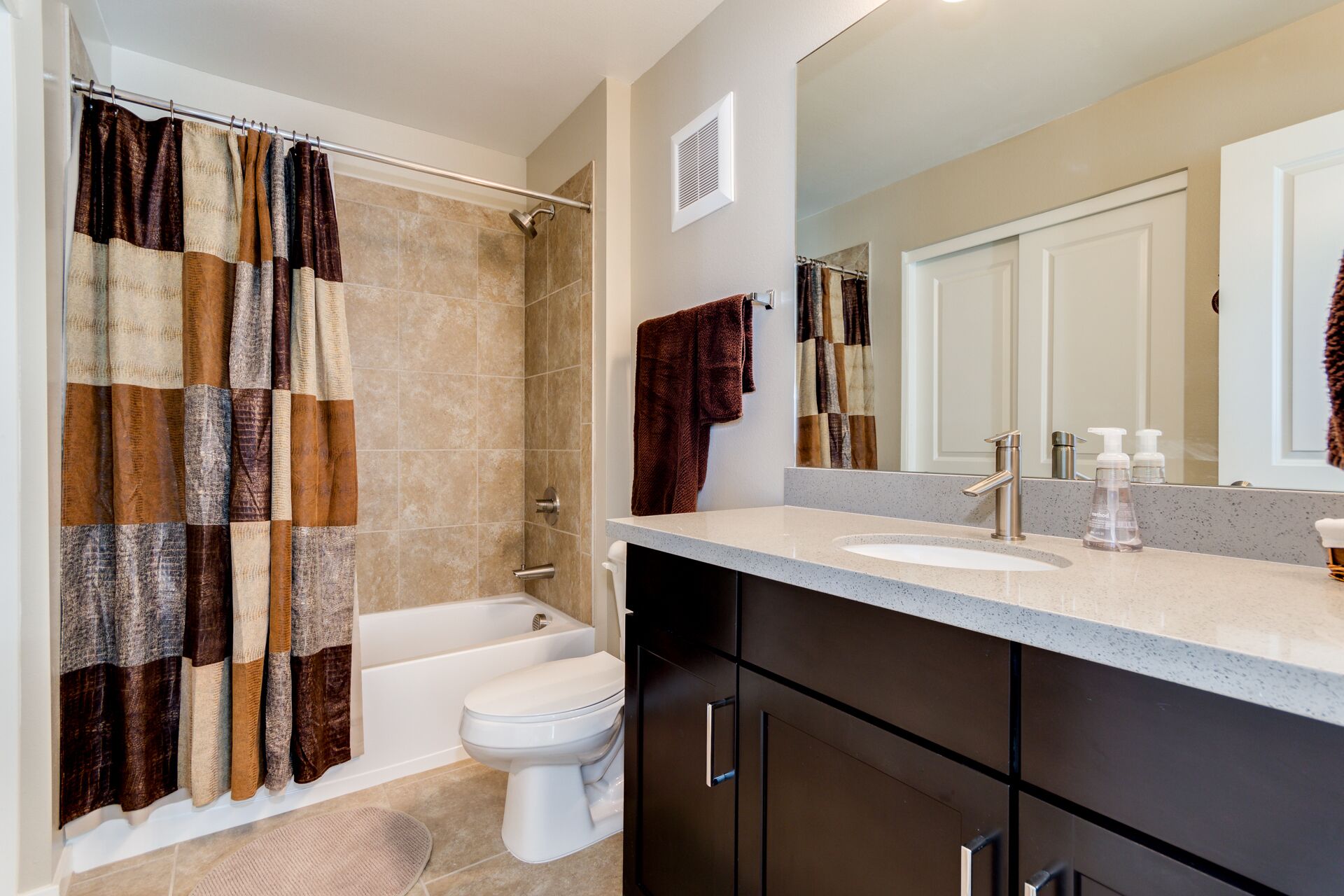 A bathroom with a shower, toilet, and sink.