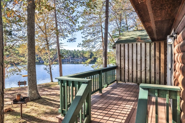 A wooden deck with a view of a lake and trees.