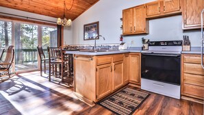 A spacious kitchen with wooden cabinets, a large island, and a built-in oven.