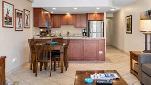 Una cucina moderna con mobili in legno, elettrodomestici in acciaio inossidabile e un'area pranzo con tavolo e sedie.