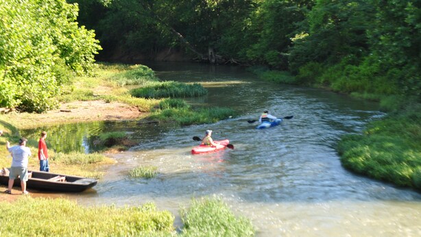 Une rivière où l’on peut faire du kayak, avec des gens sur la rive.