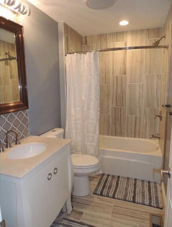A bathroom with a sink, toilet, and bathtub.