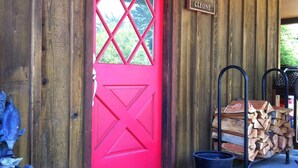 A red door with a diamond pattern, a welcome mat, and a sign reading "Chateau Cléone".