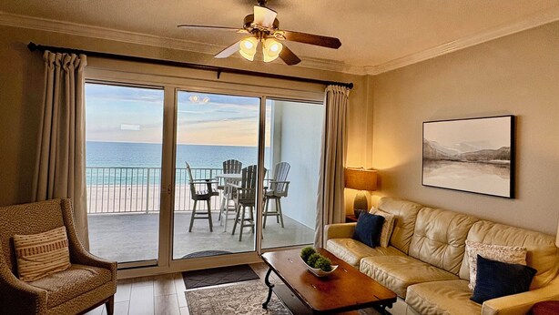 A room with a sofa, chairs, a coffee table, a ceiling fan, and a view of the ocean through large sliding doors. - RI 410 Huge Double Shower! Beach Front! Popular Unit! Kitchen & Bath Upgrades (Orange Beach)