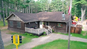 A wooden cabin with a porch, a deck, and a sign welcoming visitors to The Timber's Bar & Grill.