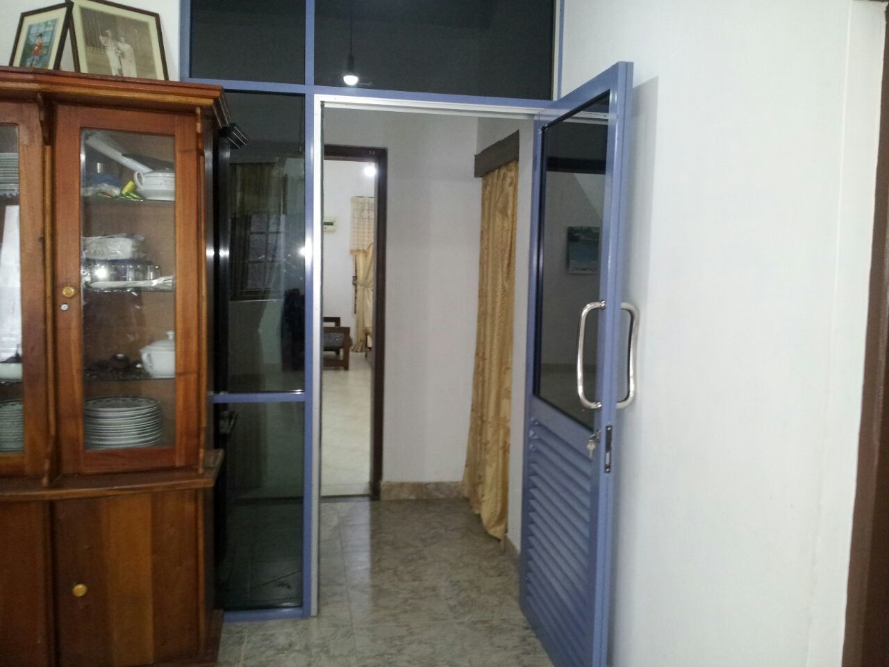 A room with a wooden cabinet, a sliding glass door, and a blue door.