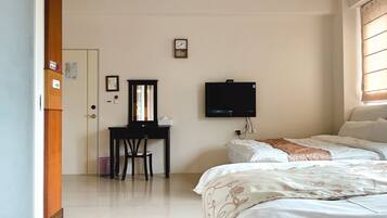 Habitación de hotel con cama, escritorio con silla, televisor y ventana con persianas.