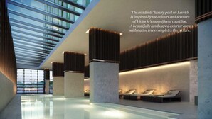 A luxury pool area with a modern design, featuring a glass ceiling and a view of the coastline.