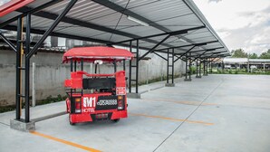 Un camion-restaurant rouge est garé sous un abri doté d’un sol en béton et de marquages au sol orange pour les places de stationnement.