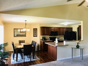 Una cocina moderna con armarios de madera, un microondas negro y un refrigerador de acero inoxidable.