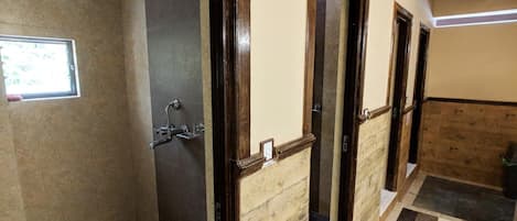 Un baño de hotel con ducha, ventana y piso de baldosas.