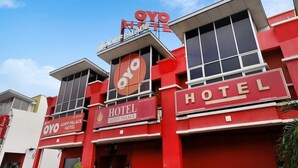 Un edificio rojo con un letrero que dice "OYO Hotel Adiff Palace".
