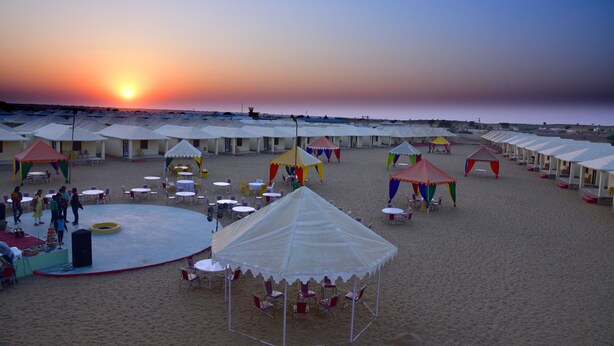 A beachside event with tents and tables set up for an outdoor gathering.