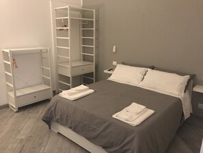Una camera da letto con un letto, un armadio e un comodino.