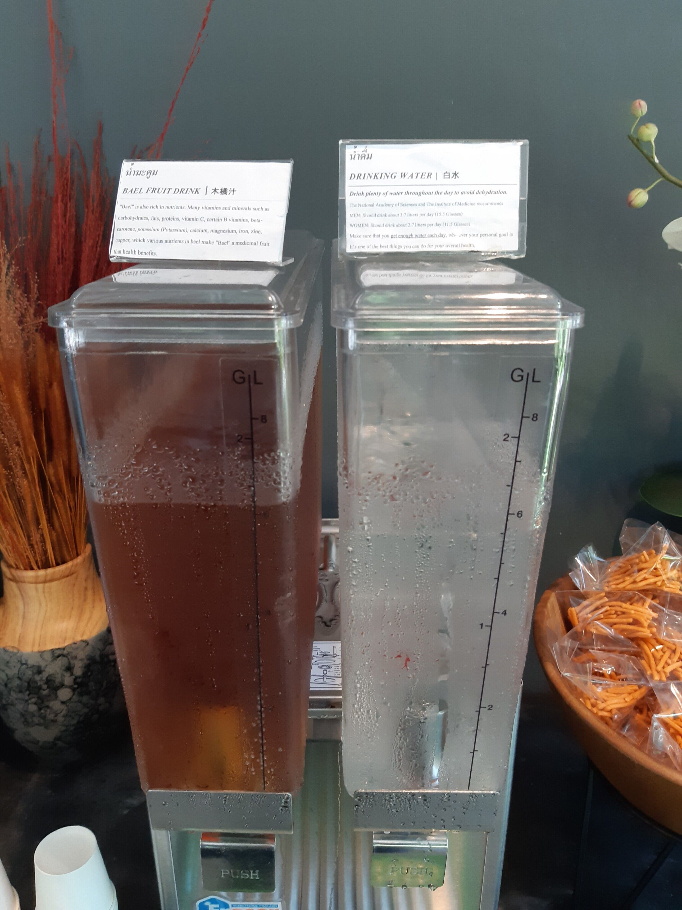 Dos dispensadores de agua con balanzas integradas, uno con un líquido marrón y otro con agua transparente.