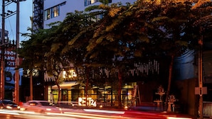 A multi-story hotel with a modern design, featuring a prominent entrance and a balcony on the upper floors. - Rest24 Residence (Bangkok)