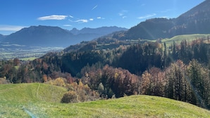 A mountainous landscape with a clear sky and sunlight filtering through trees. - 6 people Apartment / Auerbach (Oberaudorf)