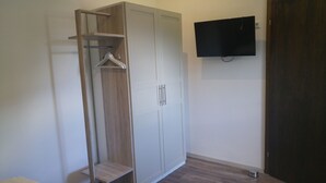 A room with a wardrobe, a television mounted on the wall, and a wooden floor. - Apartment in the house Heidinger (Oberaudorf)