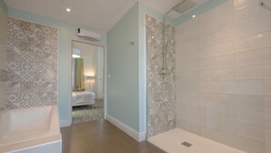 Un baño moderno con bañera, ducha y azulejos estampados.