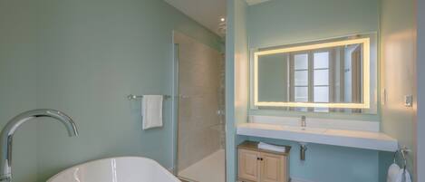 Ein Badezimmer mit Badewanne, Dusche, Waschtisch mit Spiegel und Toilette.