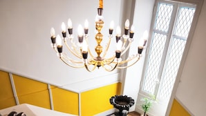 Una escalera con un candelabro, una planta en maceta y baldosas de suelo estampadas.