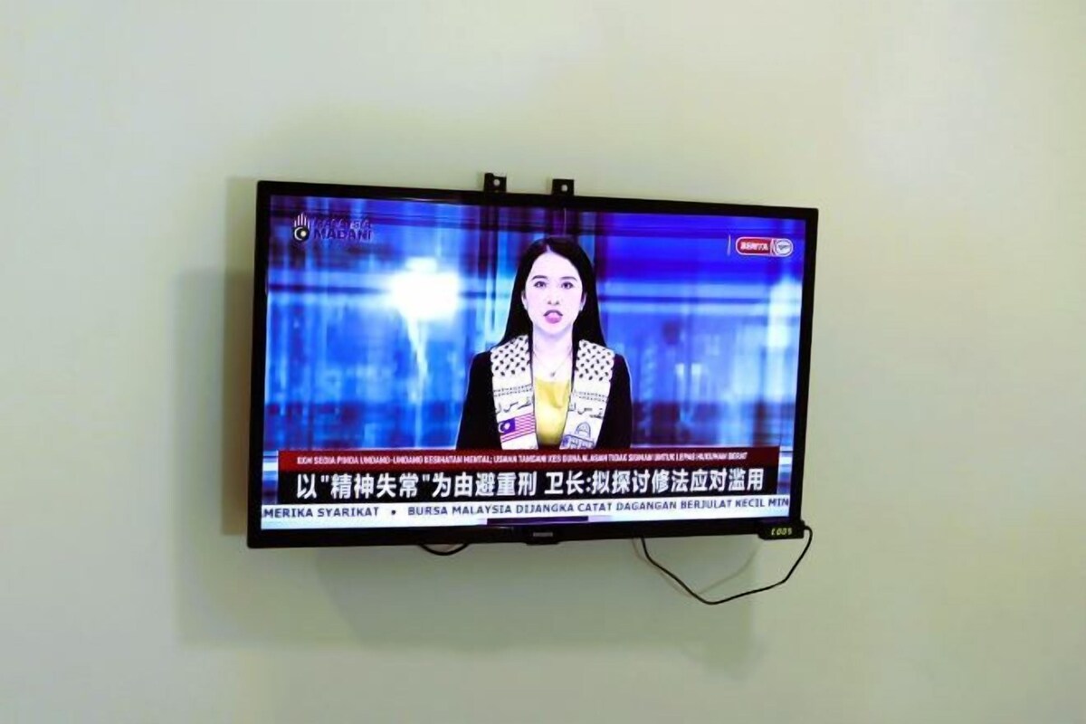 A television mounted on a wall displaying a news broadcast with Chinese text.