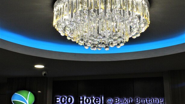 Um candelabro com vários elementos de cristal e uma placa com o nome ECO Hotel @ Bukit Bintang.