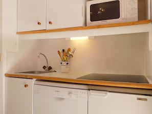 A compact kitchen with a microwave, sink, and Bosch dishwasher.