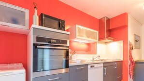 A modern kitchen with grey cabinets, a stainless steel oven, a microwave, and a dishwasher. - 3-Room Apartment 6 Pers, Balconies, Pets Allowed, Near Shops (Le Monêtier-les-Bains)