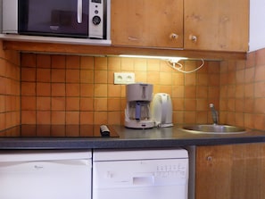 A kitchen with a microwave, coffee maker, and dishwasher.