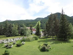 Un hotel con vistas a la montaña, rodeado de vegetación exuberante y árboles.