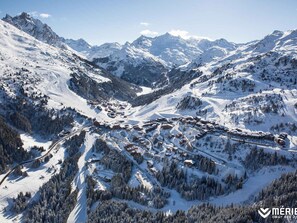 Escape to a serene alpine retreat with traditional lodges and cabins amidst snow-covered slopes and ski trails.