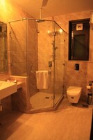 A modern bathroom with a glass-enclosed shower, a white toilet, and a sink with a mirror.