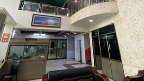 Un hall d’hôtel au design moderne, agrémenté d’un aquarium en verre, de sièges confortables et d’un plafond décoratif.