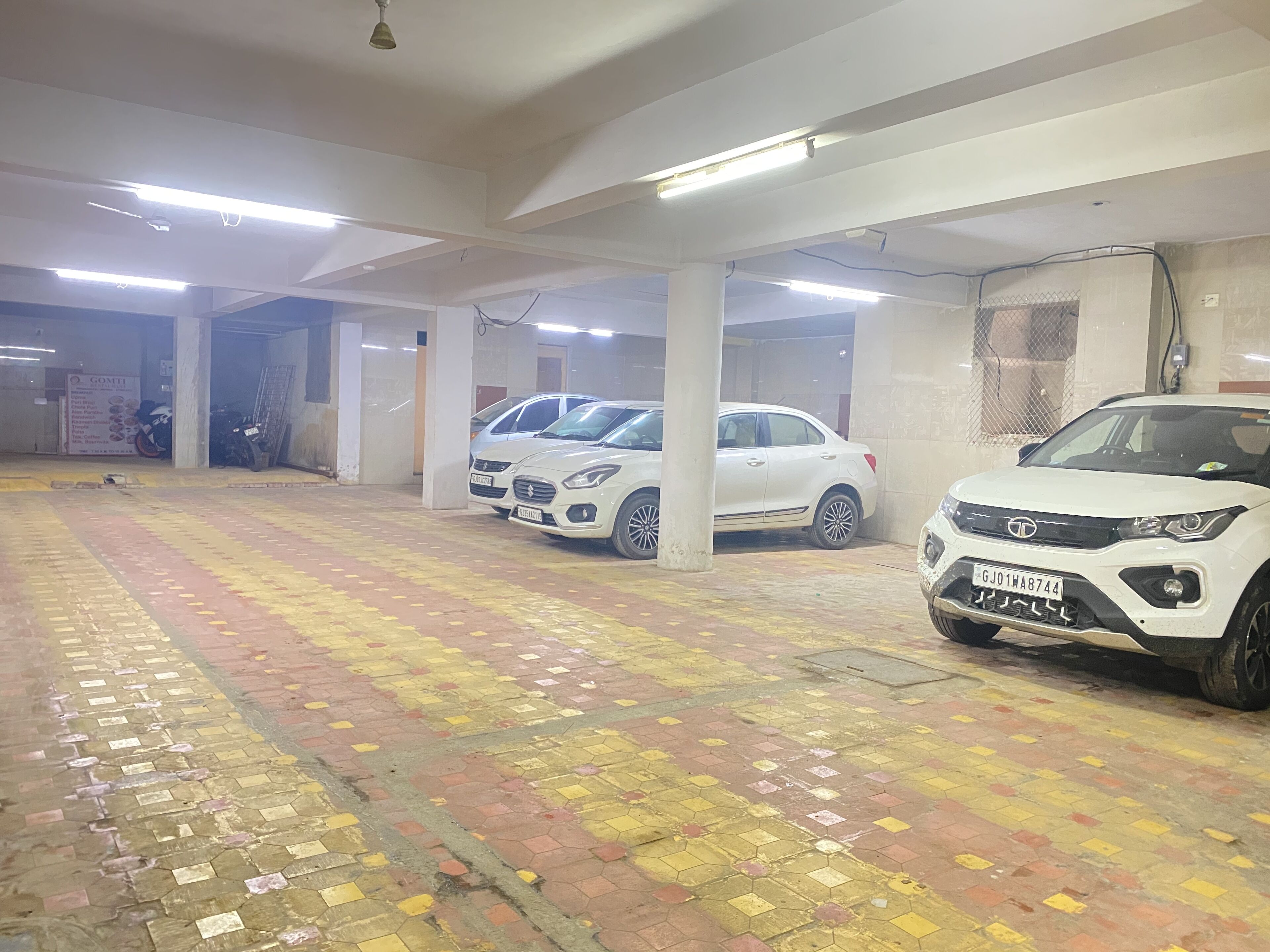 A parking garage with multiple white cars parked.