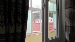 Una ventana con vista a una valla roja y un edificio.
