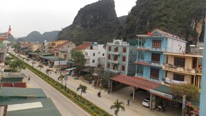 Vista de una calle con edificios, una carretera y montañas al fondo.
