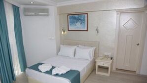 A hotel room with a bed, bedside table, and a wardrobe. - Geo Beach Hotel Marmaris (Marmaris)