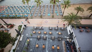 A rooftop terrace with rows of sun loungers and tables, overlooking a beach with palm trees. - Geo Beach Hotel Marmaris (Marmaris)