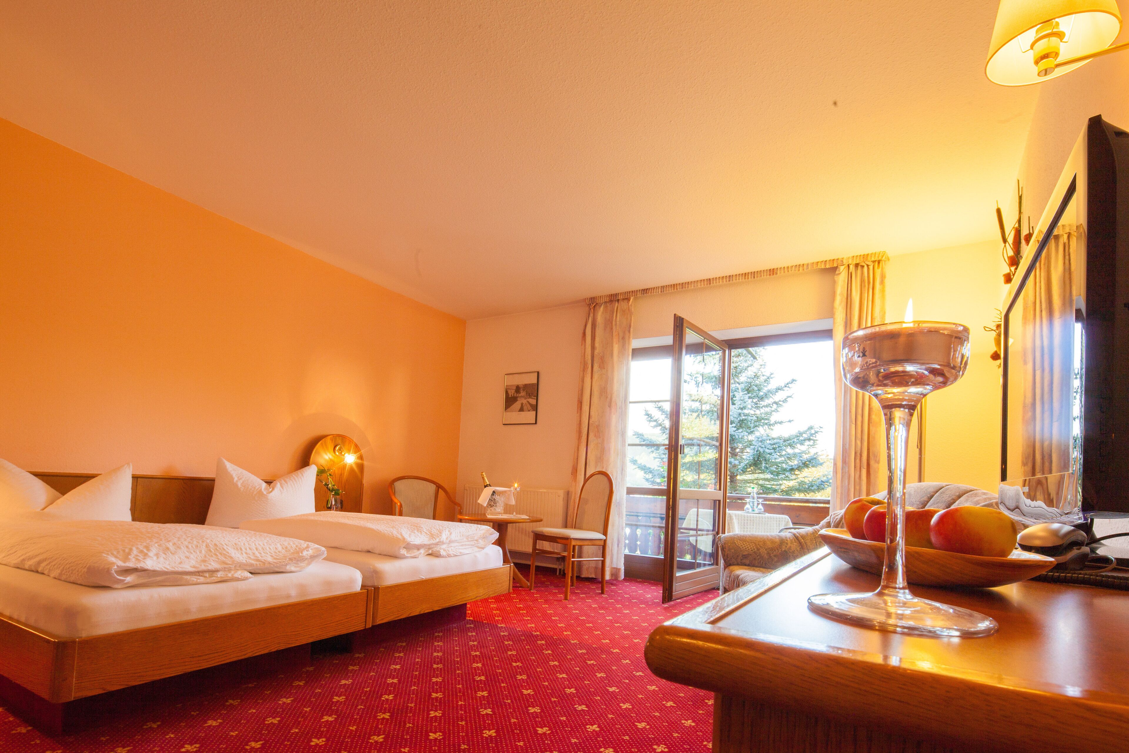 Una habitación de hotel con una cama, una silla, una mesa y un ventanal con vistas.