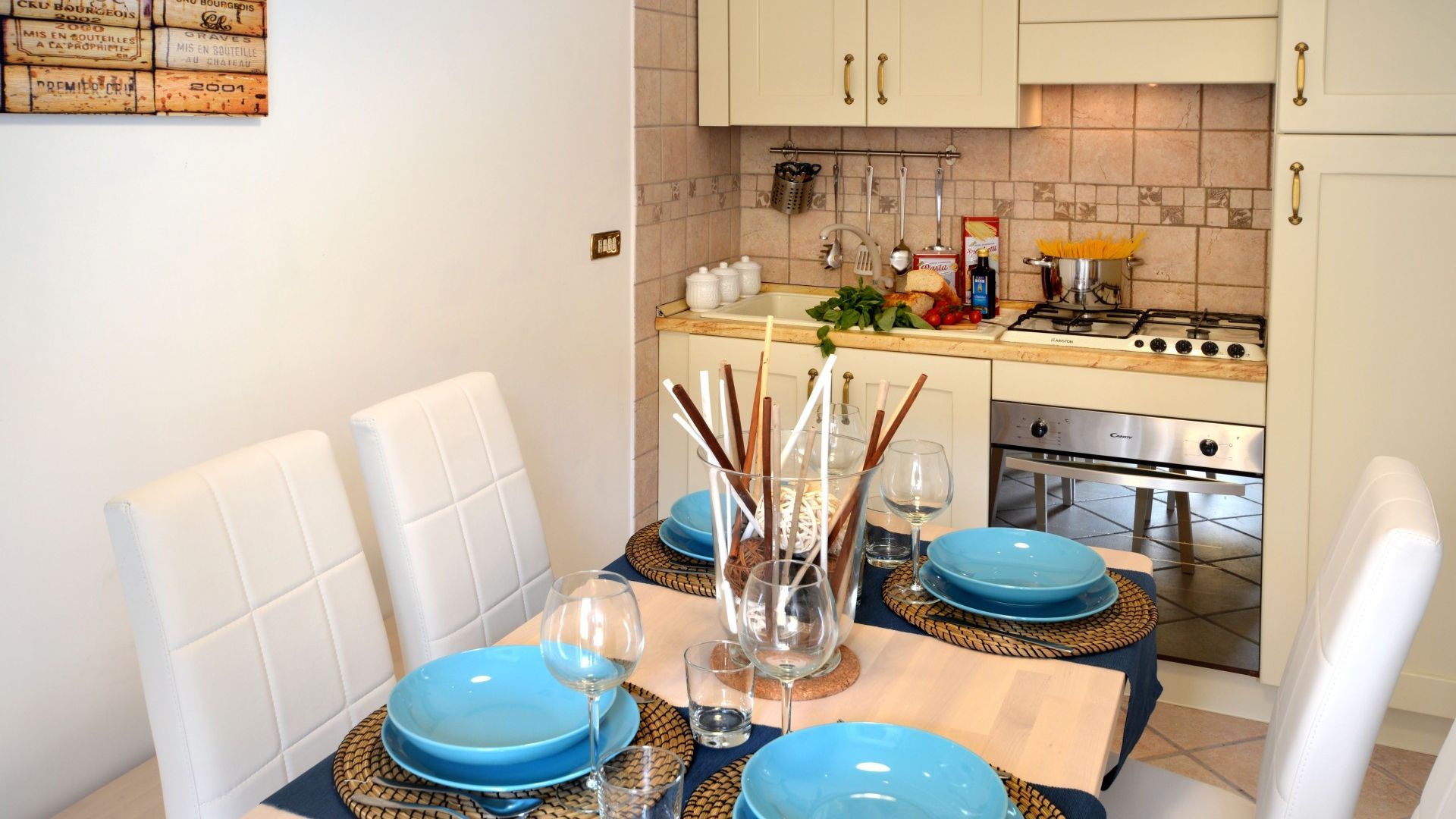 A dining area with a table set for four, a stove, and a tiled backsplash.