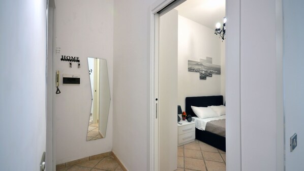 A bedroom with a bed, bedside table, and a wall-mounted cityscape picture.